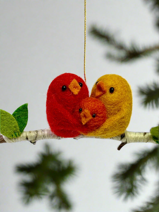 Needle felted ornament with a red and yellow bird holding an orange baby bird